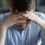 man holding his head in his hands_s