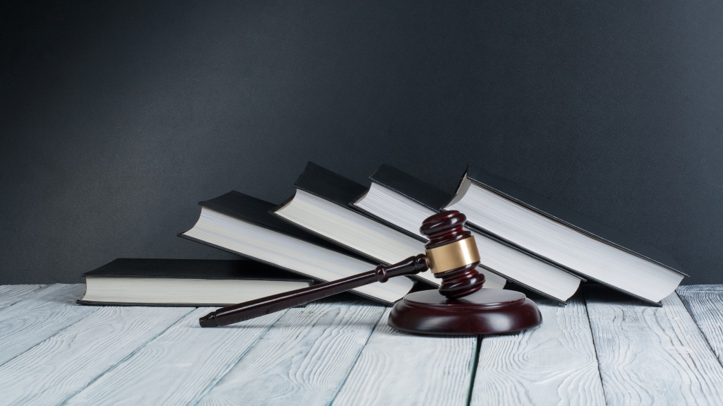Gavel in front of books on gray background