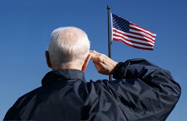 Elderly man saluting flag