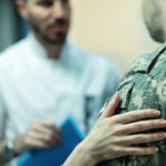 Doctor comforting soldier during VA benefits examination_s