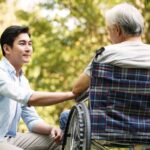 Young man helping an old man in a wheelchair_s