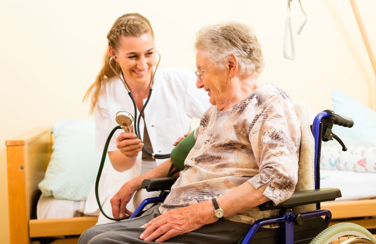 Old woman in a wheelchair with a doctor