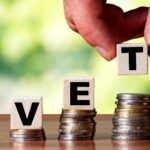 Person arranging letters that spell VET on coins_s