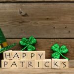 Happy St Patrick’s Day on wood background with clovers and green hat_s