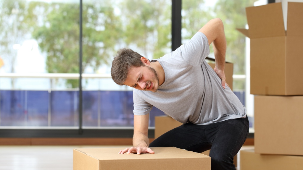 Man with hurt back with boxes