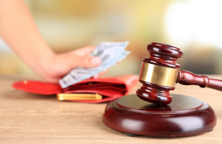 Money blurred in the background of a gavel