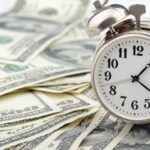 Clock on stacks of money_s