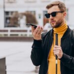 Blind man holding a cane talking into a phone_s