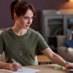 military woman using a computer with pen and paper_s