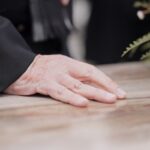 Man with a hand on a casket_s