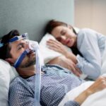Man with a CPAP machine on in bed_s