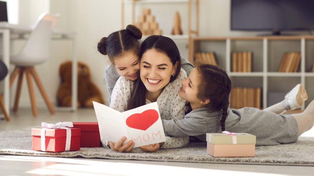 Mother with two young daughters opening a Mother's Day card