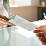 woman handing an SSDI back pay check to someone_s