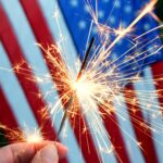 Holding,A,Sparkler,In,Front,Of,An,American,Flag,To