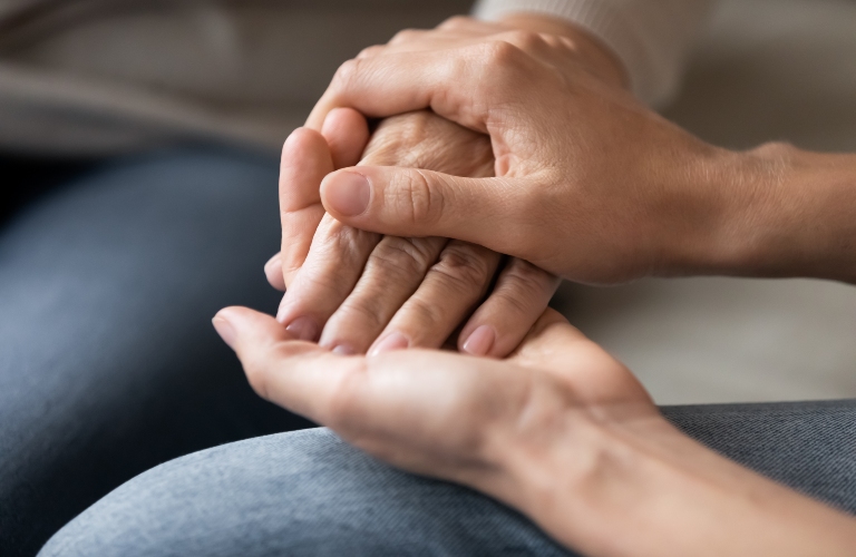 woman holding another woman's hand in support