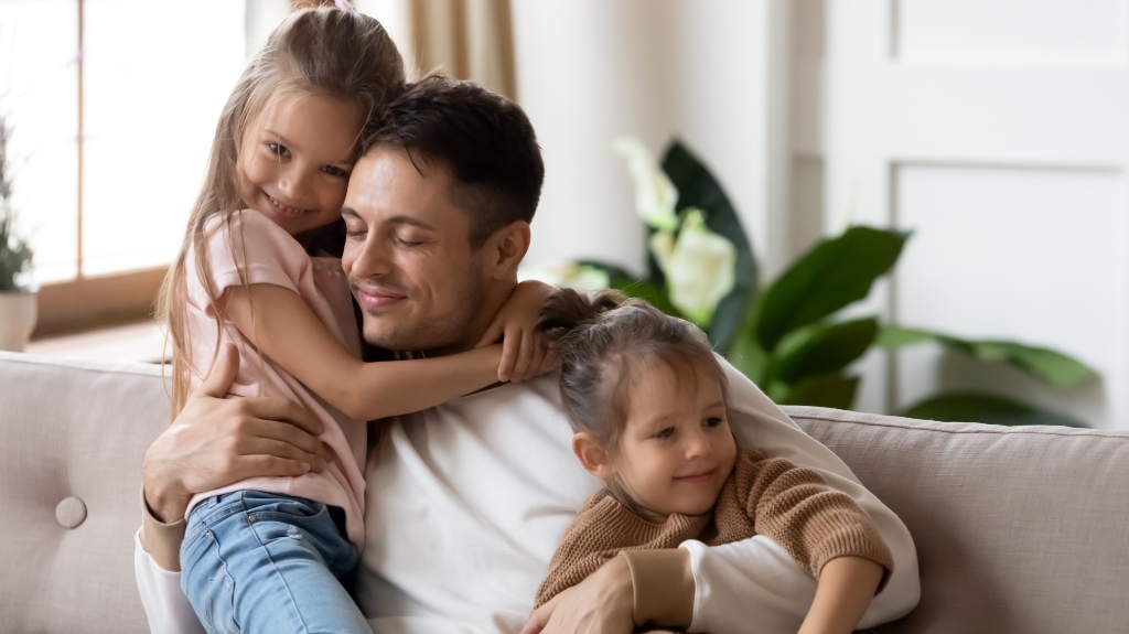 Pleased dad sit on couch with kids