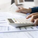 men is using calculator to calculate expenses and tax_s