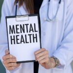 Doctor holding clipboard with Mental Health text on a sheet of paper_s