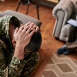 Middle aged military man holding his head_s