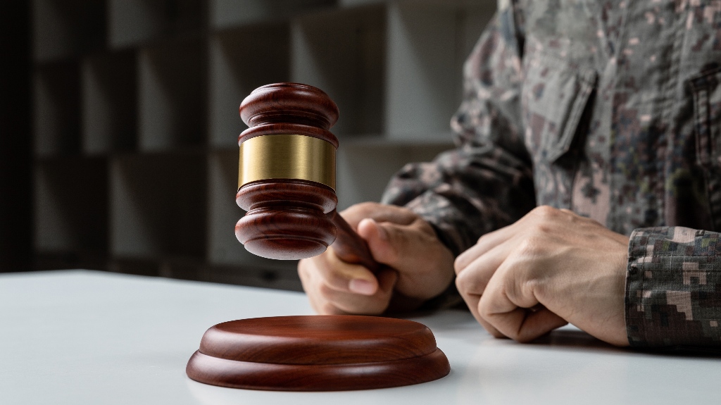Hand of soldier holding judge's gavel