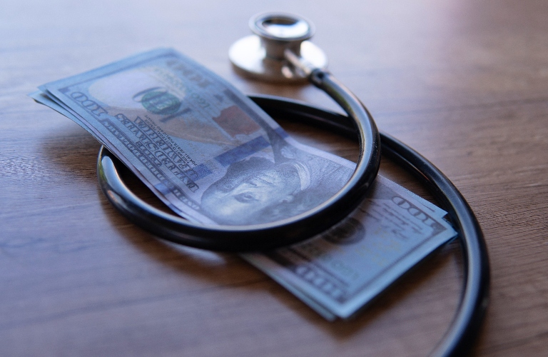 black stethoscope wrapped around money