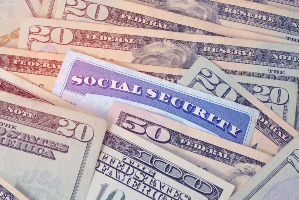 Close-up of U.S. currency bills with a Social Security card partially visible.