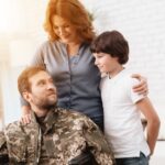 The veteran in a wheelchair with his ife and son_s