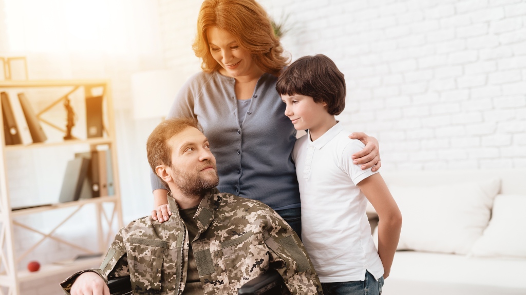 The veteran in a wheelchair with his ife and son