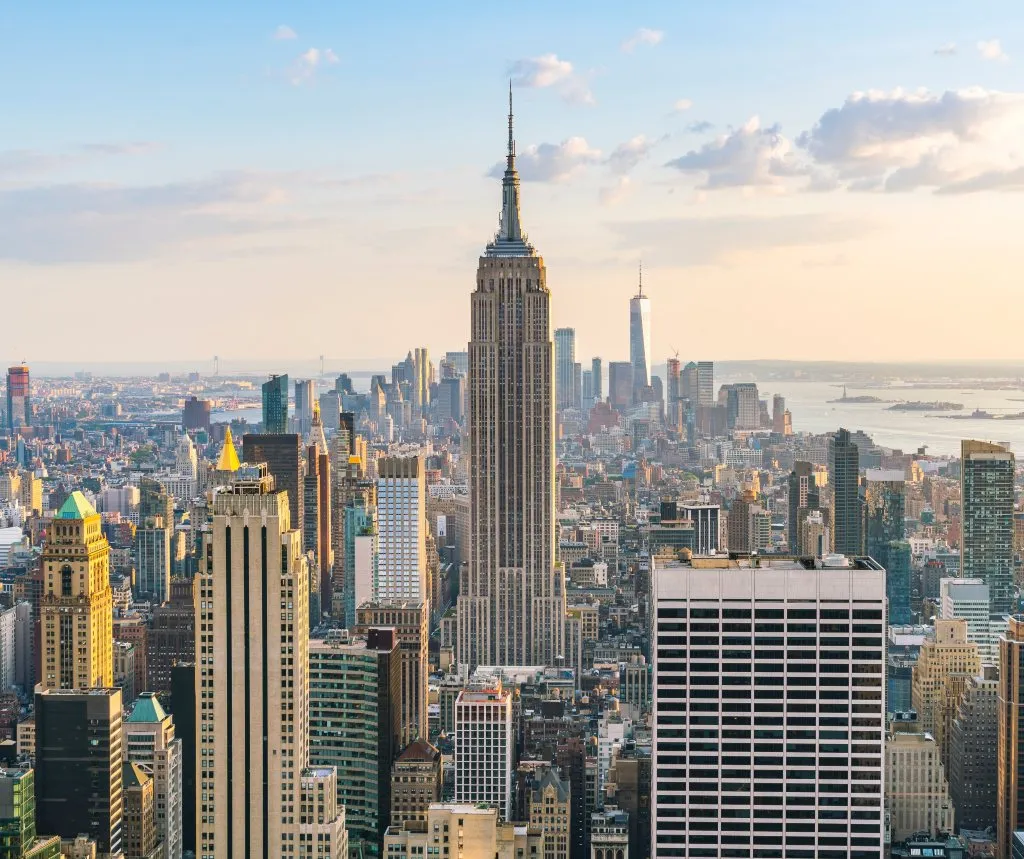 Aerial view of New York City skyline with Empire State Building at center during sunset.